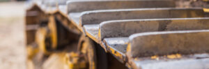 Close-up of crawler bulldozer truck. Earthmoving heavy machinery. Yellow crawler machinery. Yellow Tractor on caterpillar tracks, tractor tracks